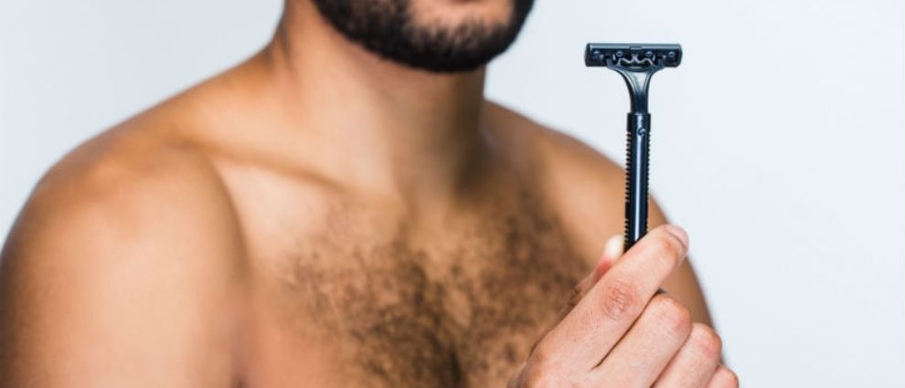 Homem segurando uma lâmina de barbear.